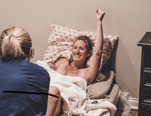 5CF8CEE5-869A-4A92-A873-92BEBBE65D4A_1_201_a (1) A woman is sitting in bed with her arm raised.