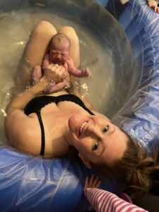 A woman and baby in a pool of water.