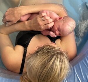 A woman holding a baby in her arms.