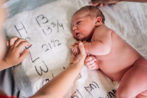 A baby is being held by someone with their hands.